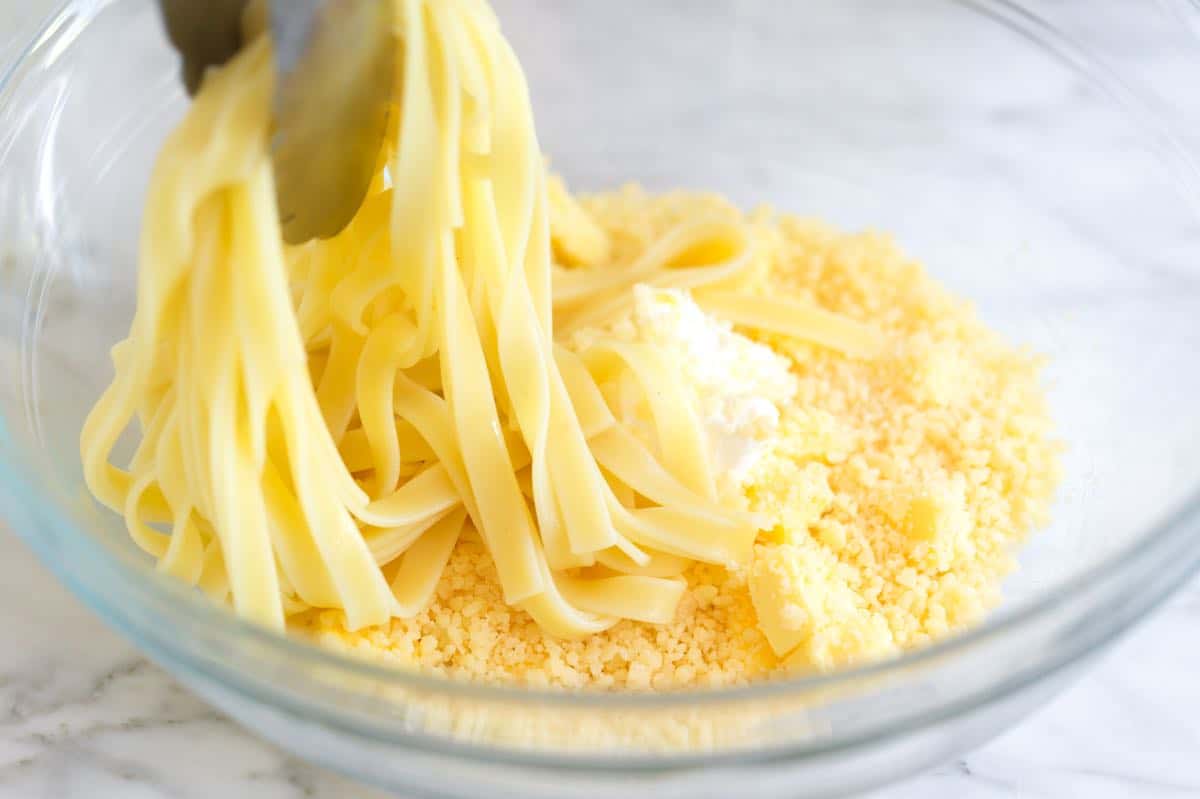 Tossing fettuccine with parmesan, butter, and pasta cooking water.