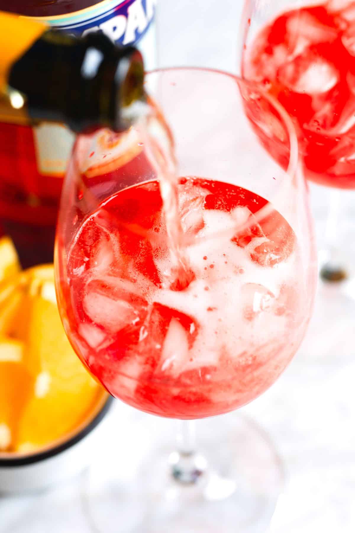 Pouring prosecco to Campari