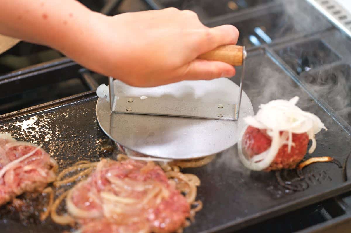 Pressing out ground beef into smash burgers using a burger press