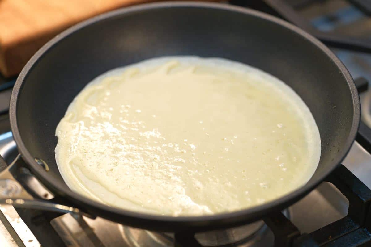 Batter for homemade Italian Crespelle in a skillet to use as manicotti shells
