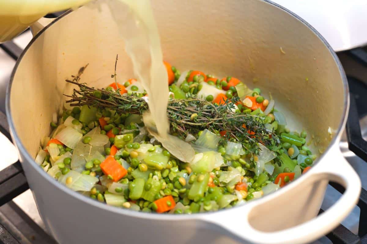 Adding the broth to make split pea soup