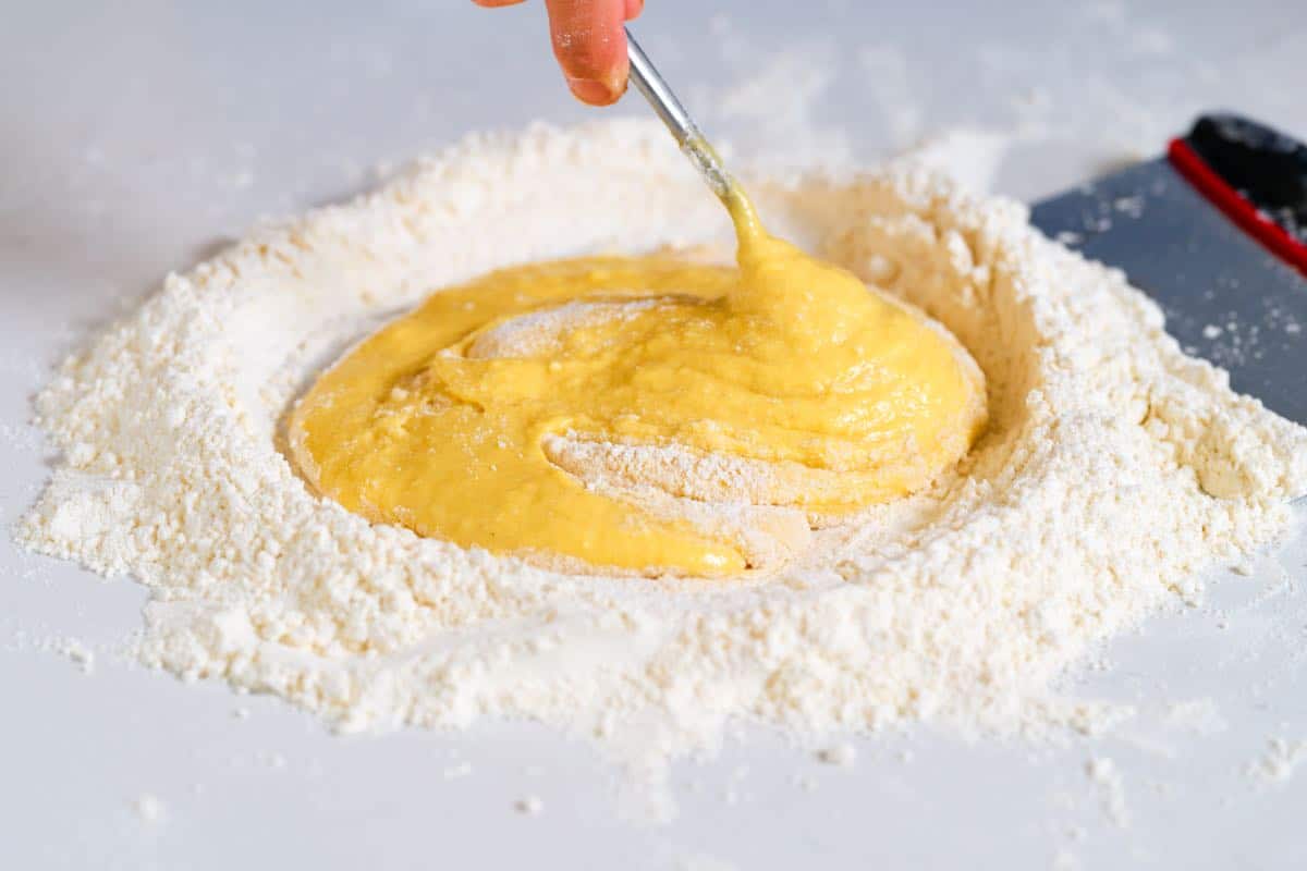 Mixing the flour into the egg mixture to make the pasta dough