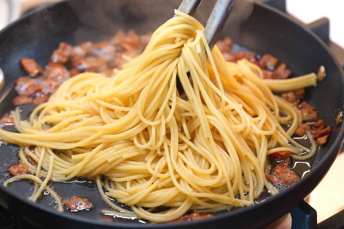Tossing pasta with rendered fat.