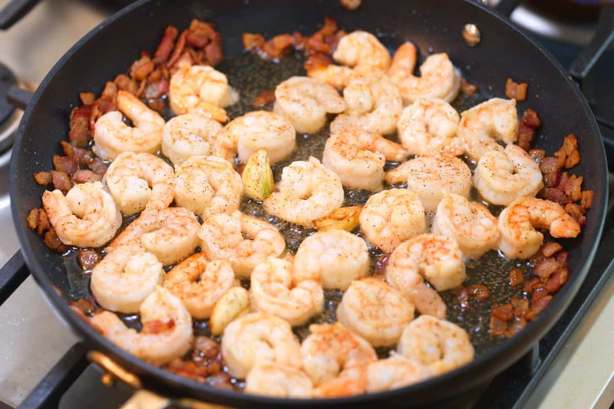 Cooking the shrimp with garlic in rendered bacon fat