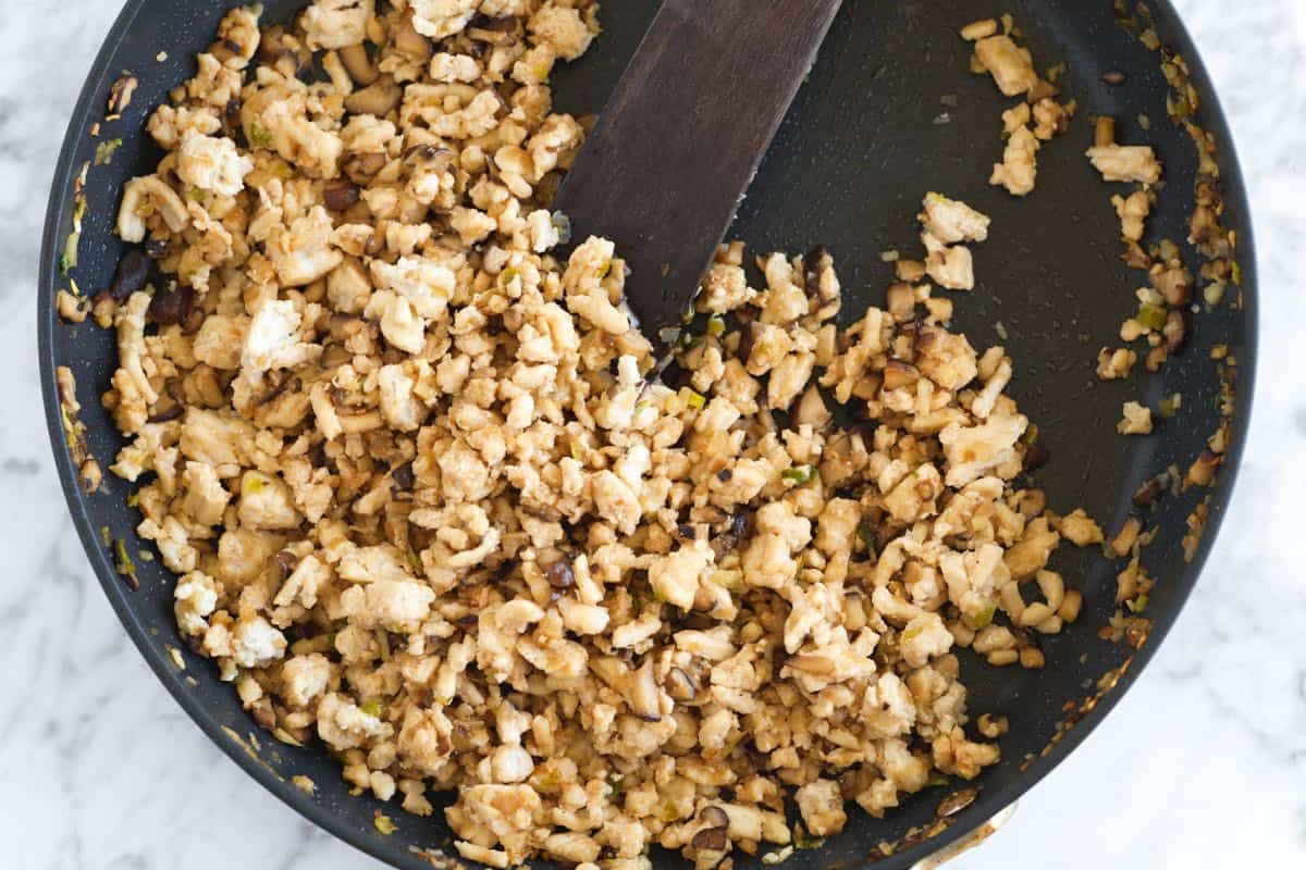 Cooking the chicken and mushroom spring roll filling in a skillet