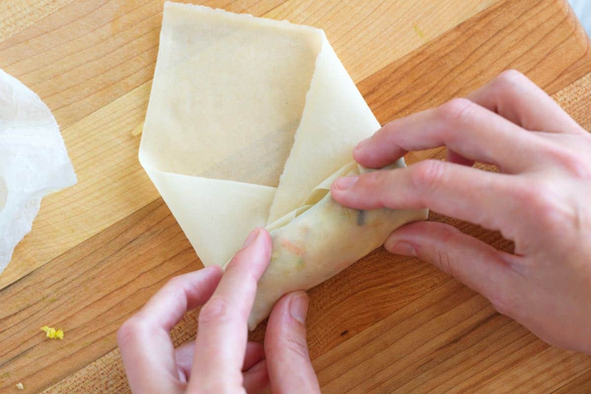 Rolling spring rolls and folding the sides over the filling