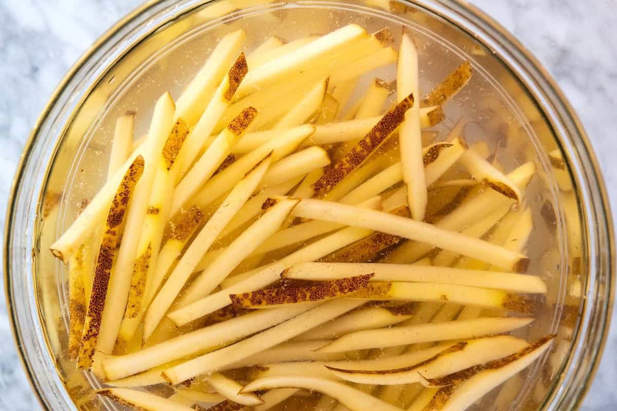 How to Make Baked French Fries: soaking cut fries in cold water