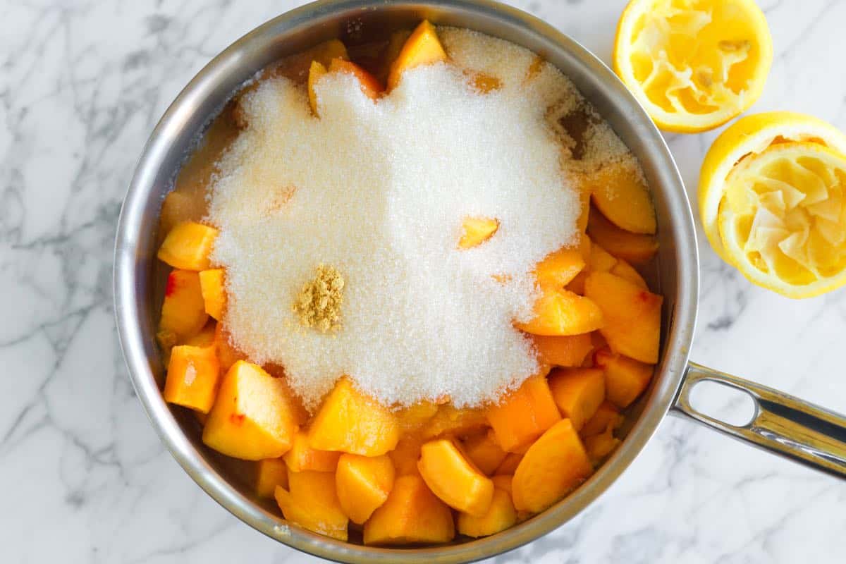 Fresh peaches, sugar, lemon juice and ginger in a saucepan.