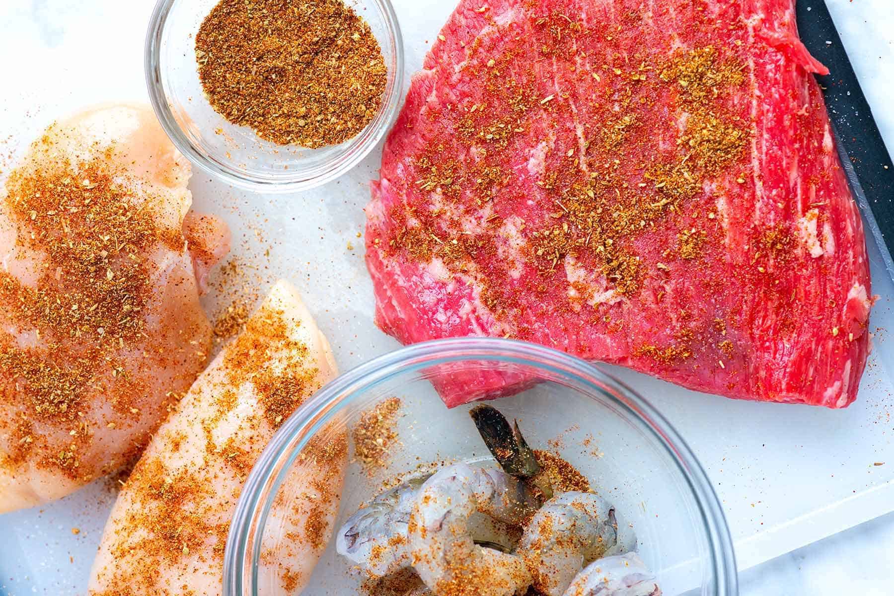 Seasoning steak, chicken, and shrimp with fajitas seasoning.