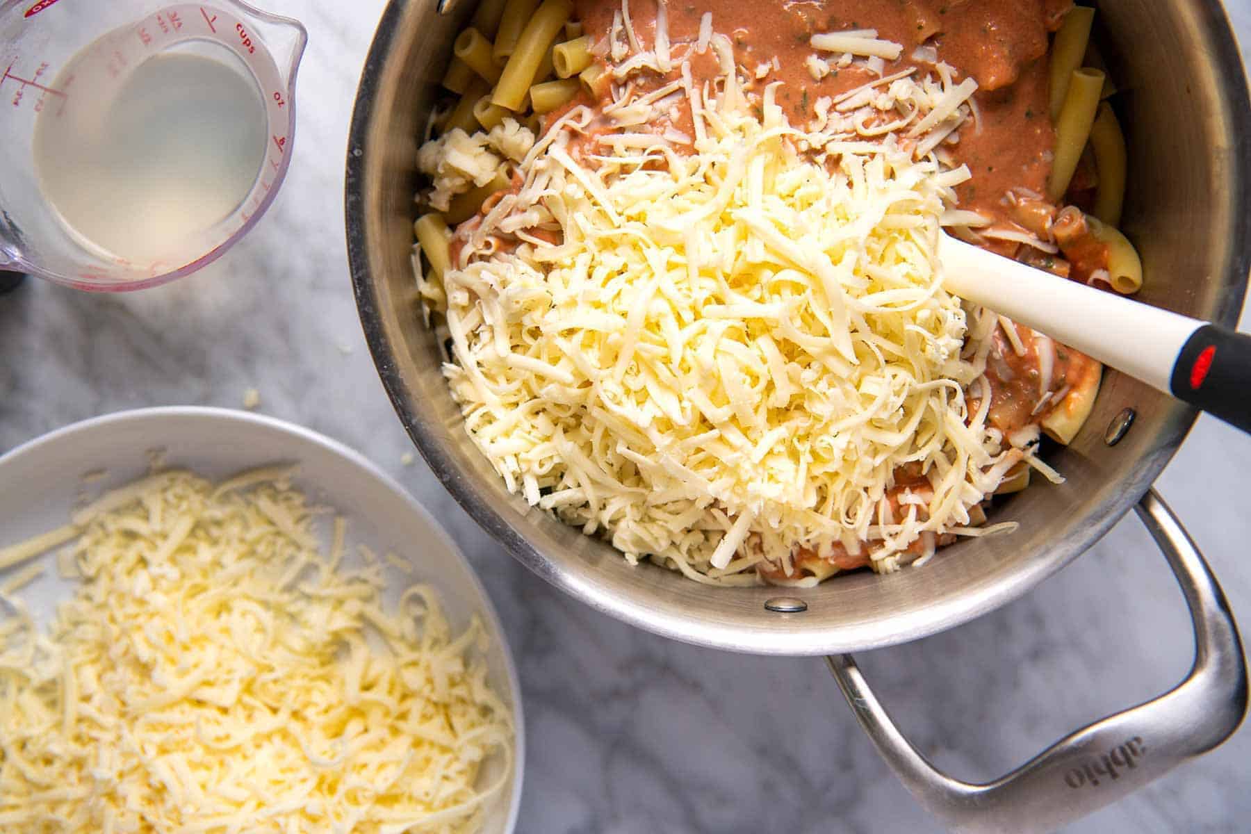 Stirring ziti with tomato sauce and cheese