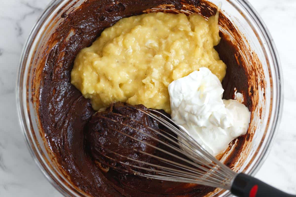 Whisking mashed banana and sour cream into chocolate banana bread batter