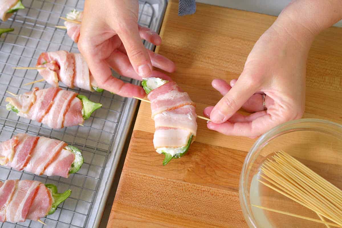 Wrapping stuffed jalapeño poppers with bacon