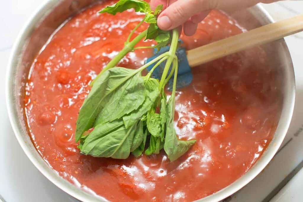 Adding basil to homemade tomato sauce