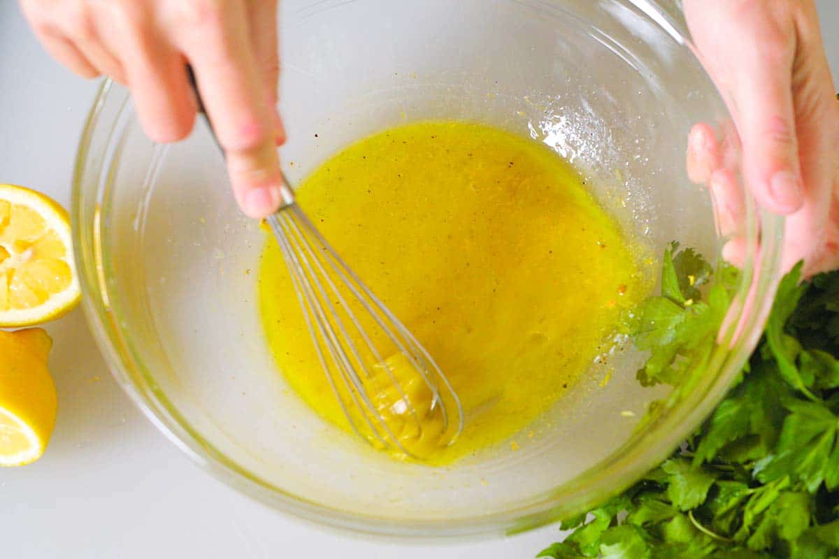 Making the orzo salad dressing in a big bowl