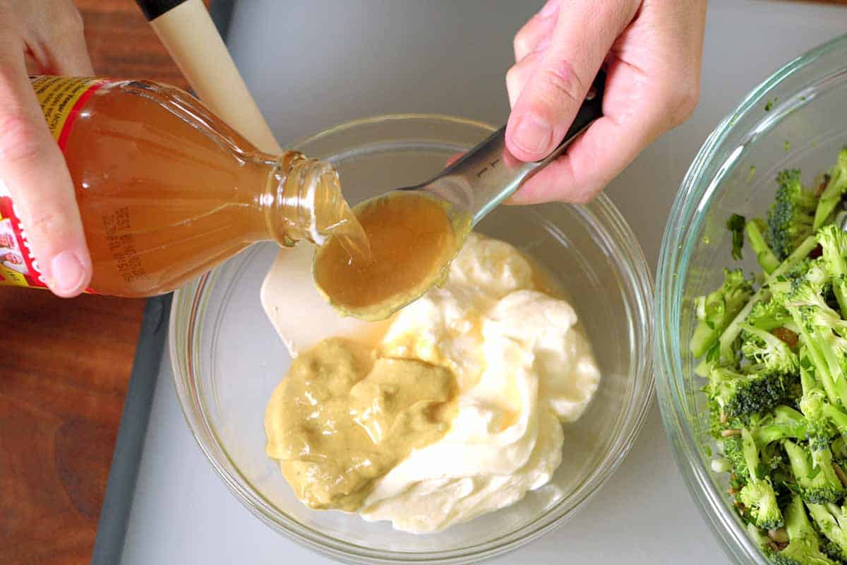 Making the broccoli slaw dressing with mayo, mustard, and apple cider vinegar