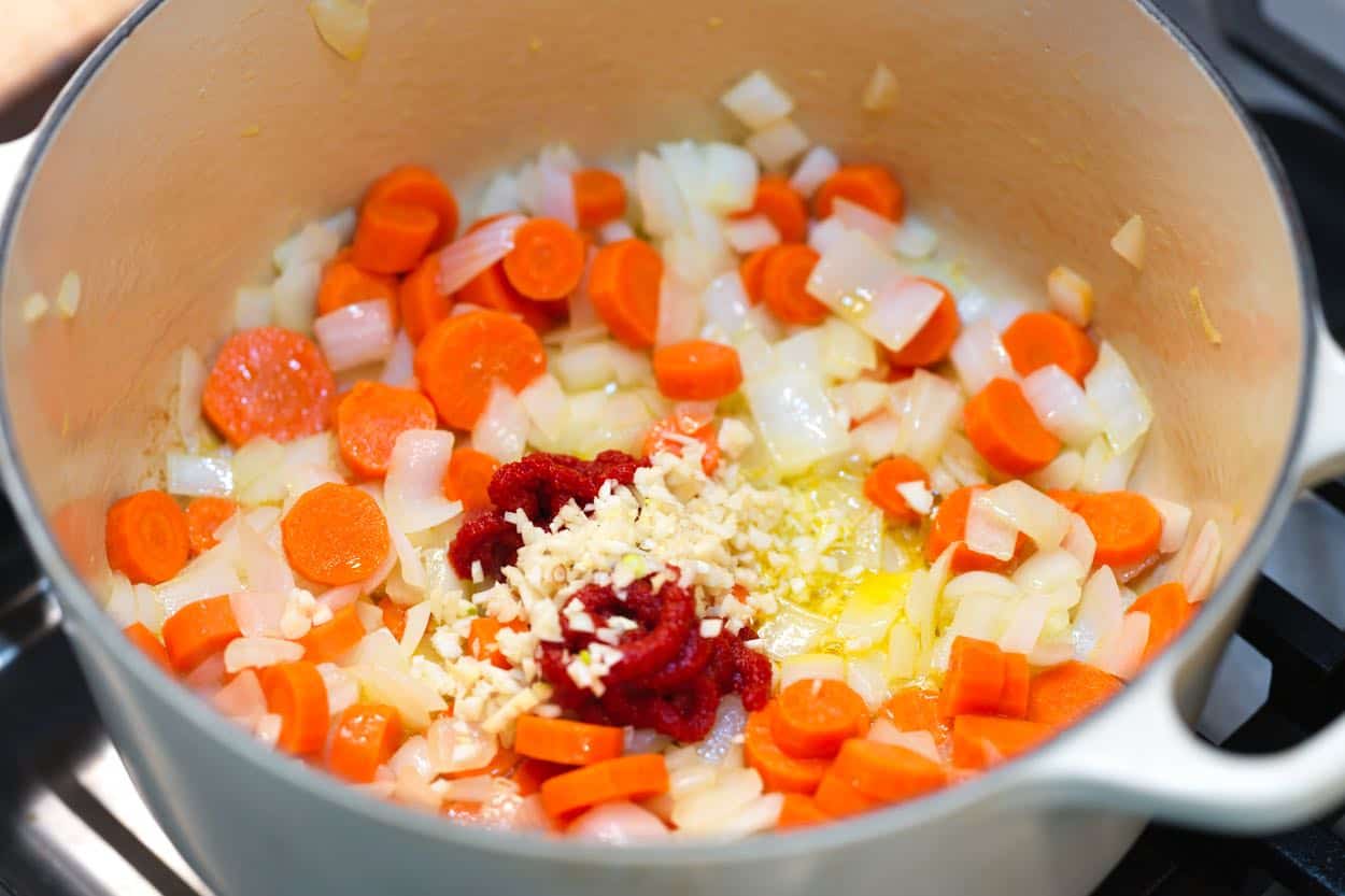 Toasting garlic and tomato paste in a soup pot for the base of cabbage soup
