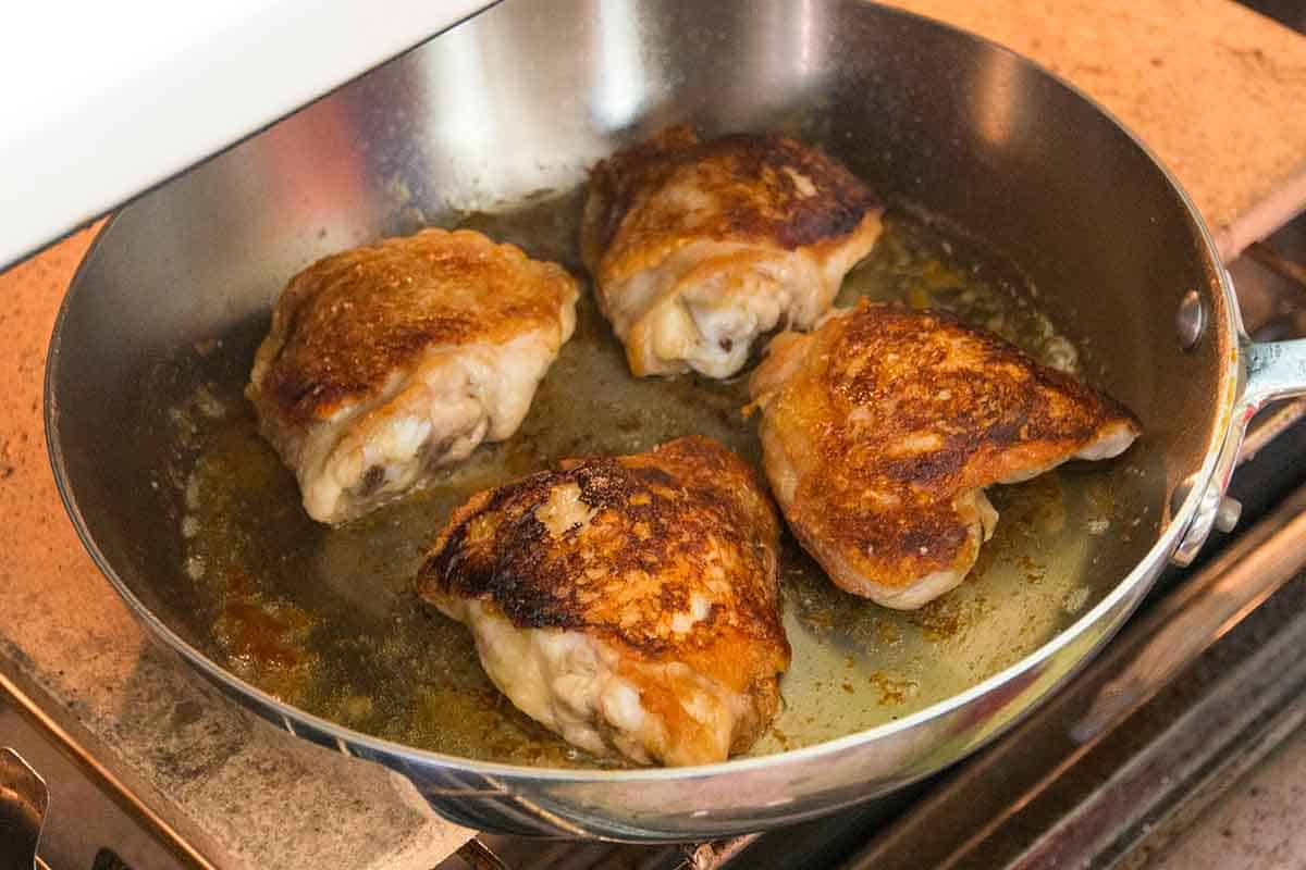 Placing chicken thighs into the oven to finish cooking before adding chimichurri sauce