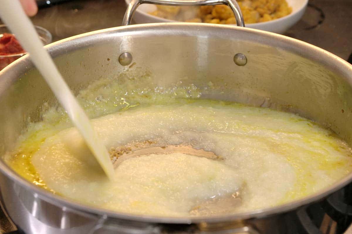 Making base of chicken curry with pureed onion, garlic, and ginger