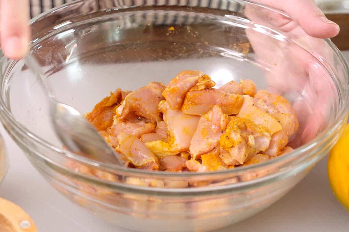 Marinating chicken in curry spices