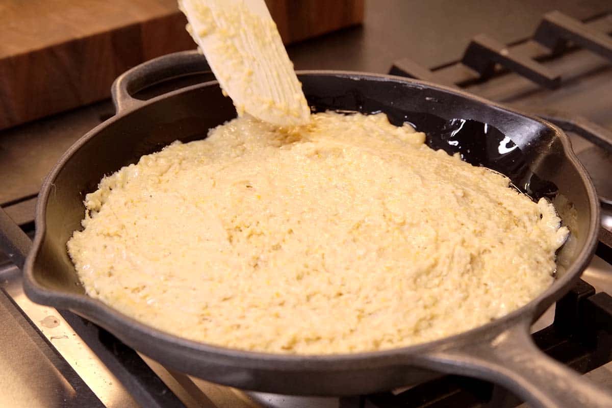 Adding cornbread batter to skillet