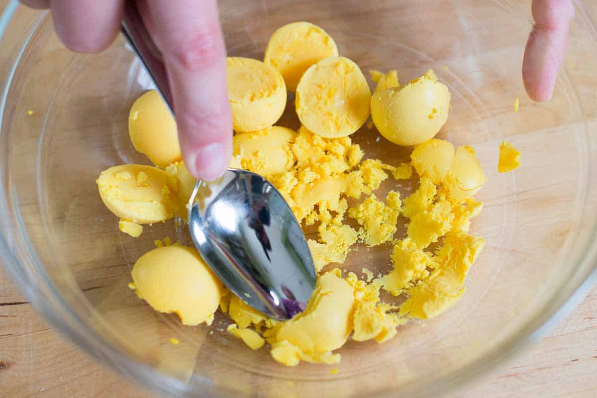 Mashing egg yolks for deviled eggs filling
