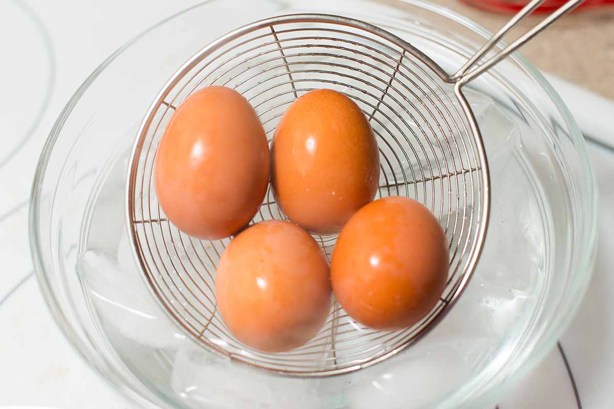 Transfering hard boiled eggs to an ice water bath for easy peeling