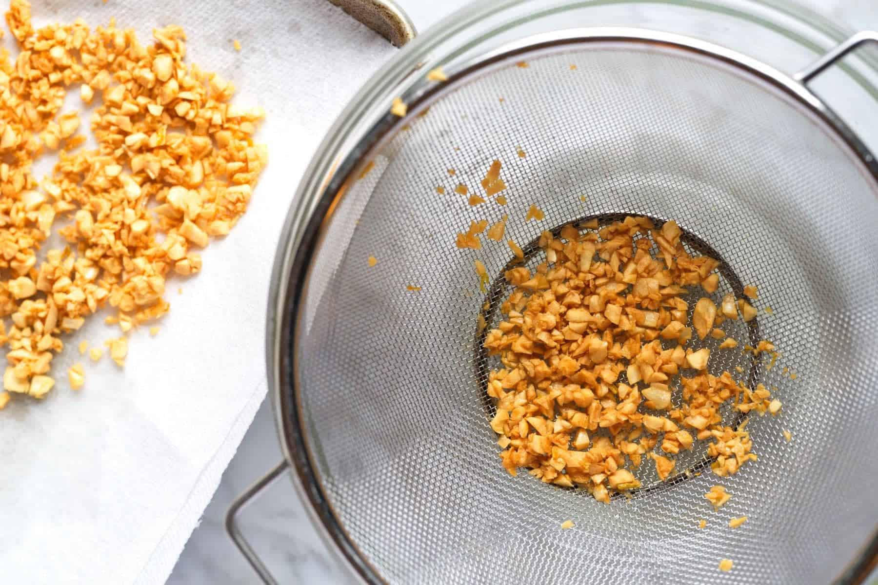 Draining fried garlic on paper towels.