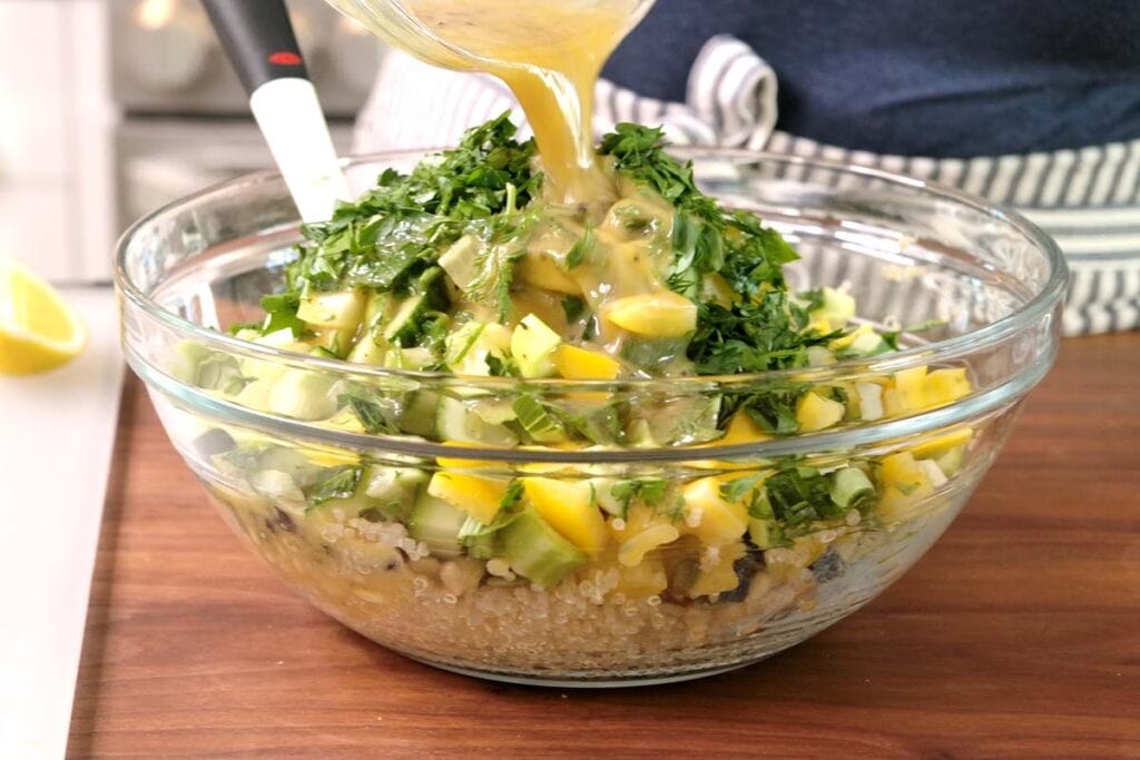 Adding dressing to quinoa salad