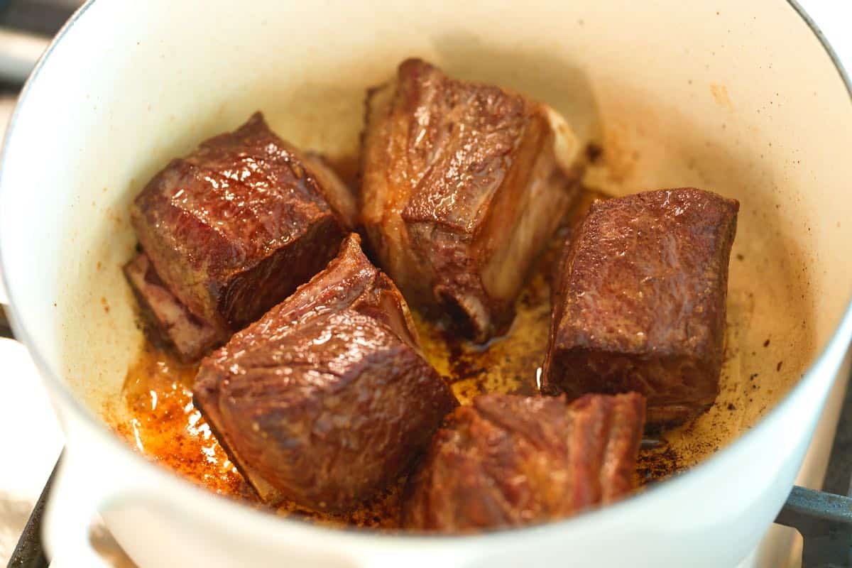 Browning beef short ribs before braising them.