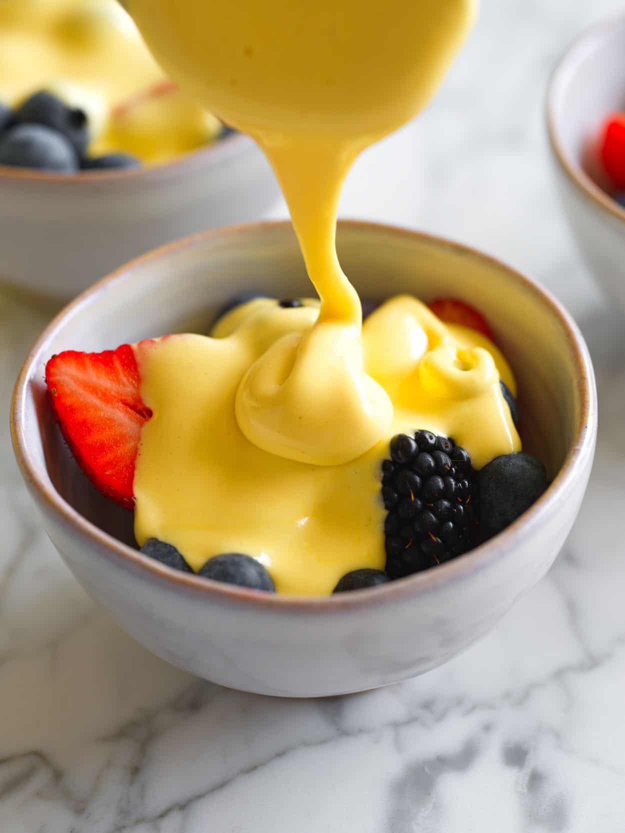 Zabaglione being poured over berries