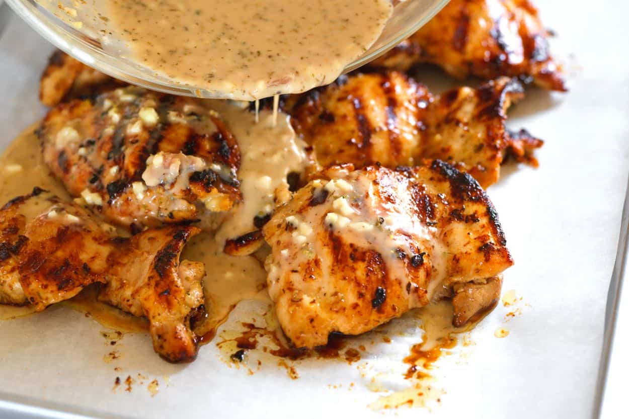 Pouring marinade over chicken before baking in the oven