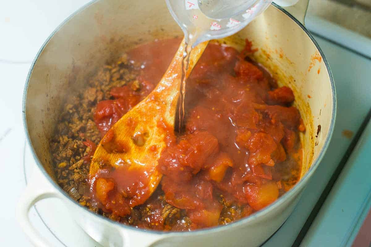 Pouring in water for the chili's sauce