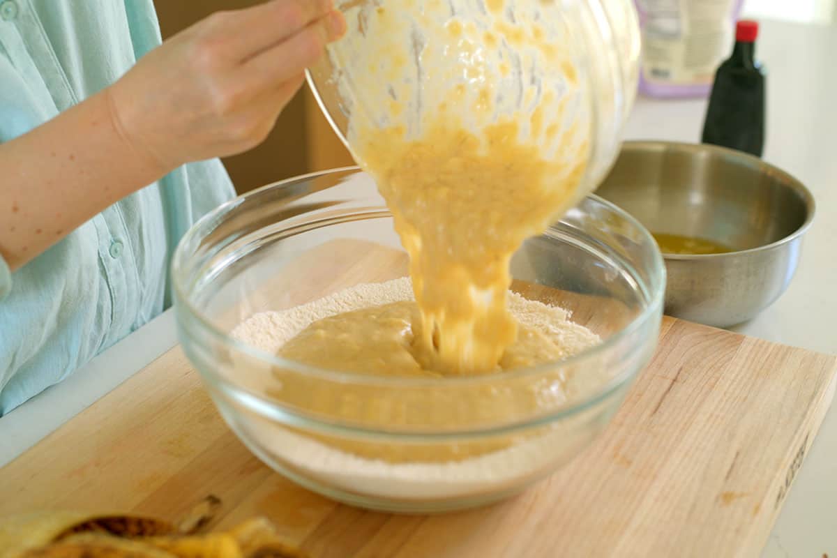 Combining dry ingredients with the wet ingredients to make the banana cake batter