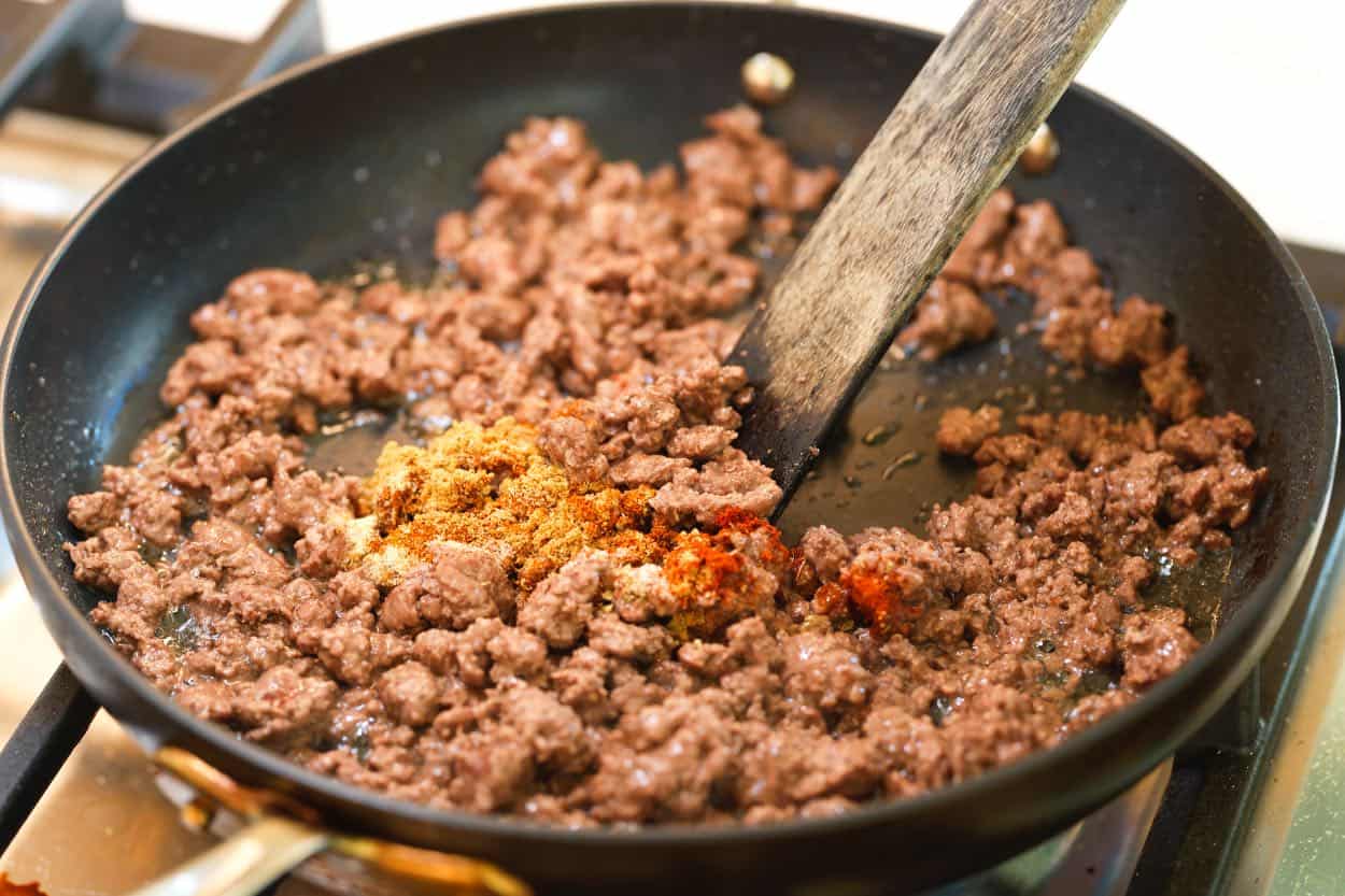 Browning lean ground beef with taco seasoning for tacos