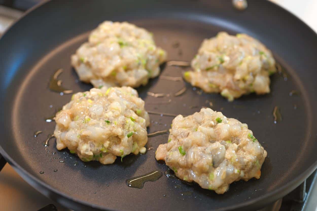 Searing shrimp burgers in a skillet