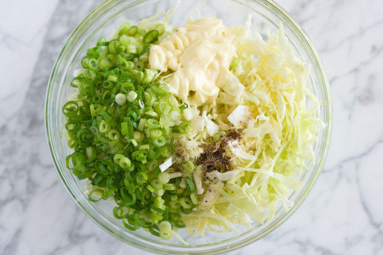 The creamy lime slaw ingredients in a bowl ready to be mixed.