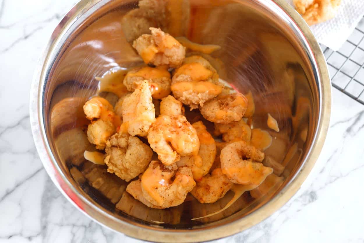 Tossing crispy fried shrimp with Bang Bang sauce