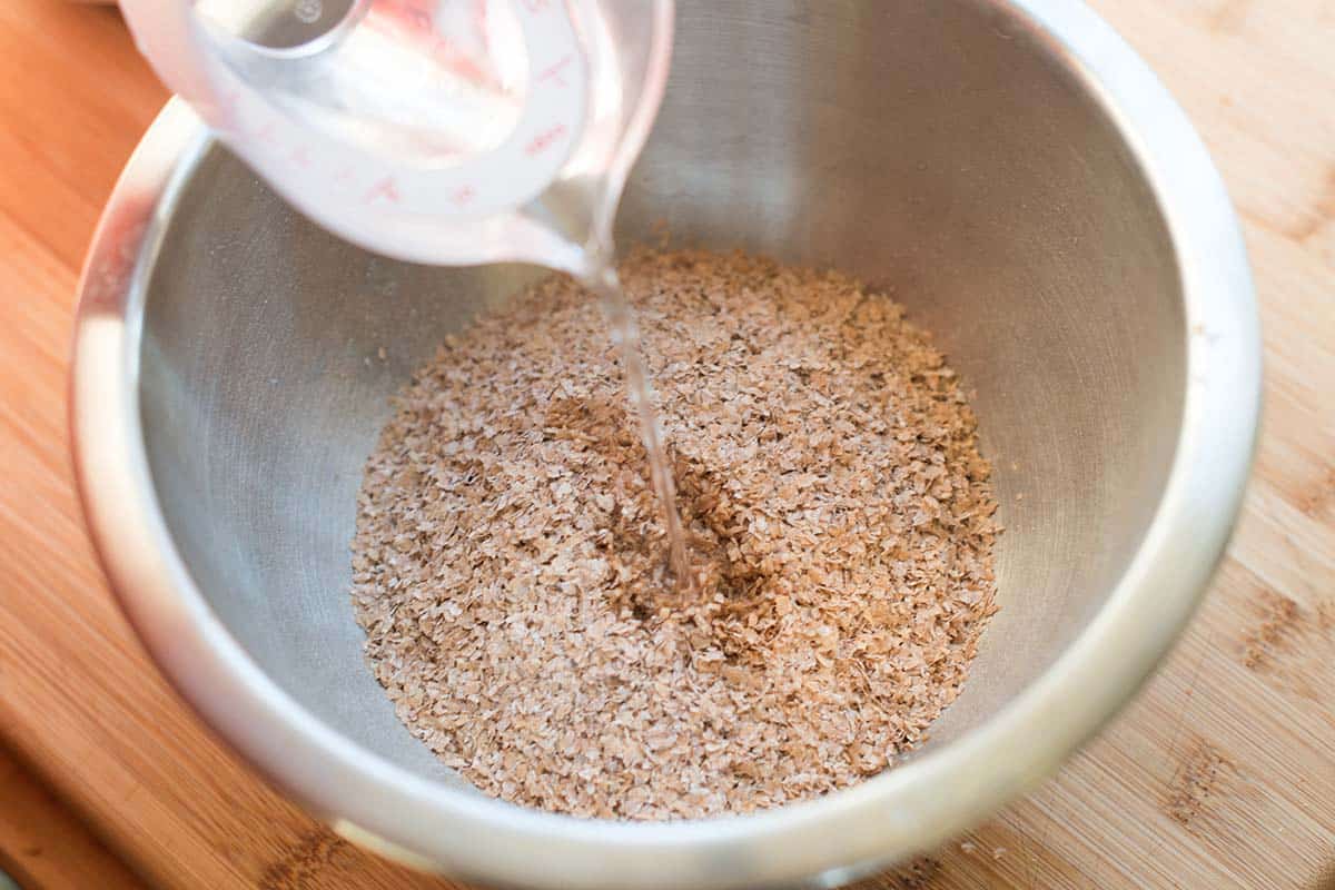pouring hot water over wheat bran to hydrate the bran for muffins