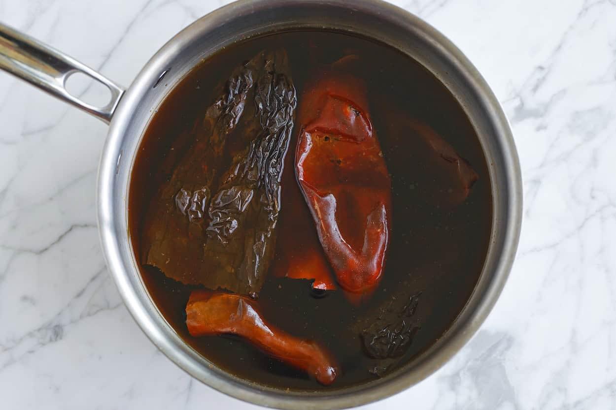 Rehydrating dried chiles in water for birria
