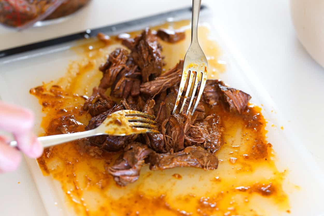 Shredding beef birria