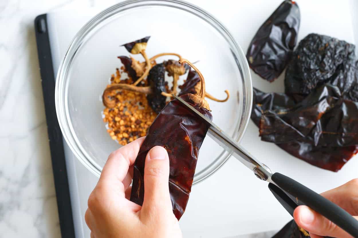 Removing the seeds from dried chiles for birria
