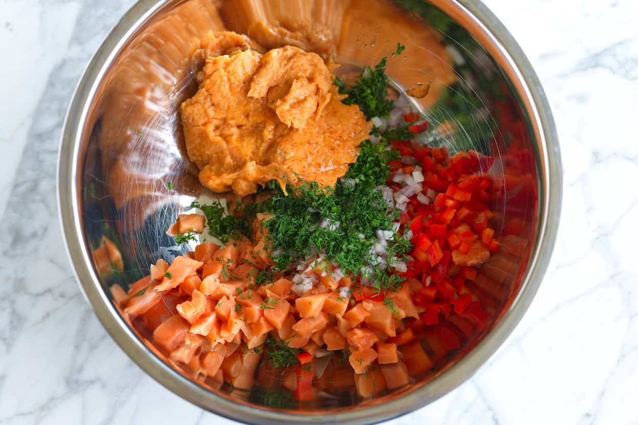 Bowl with salmon burger ingredients ready to mix