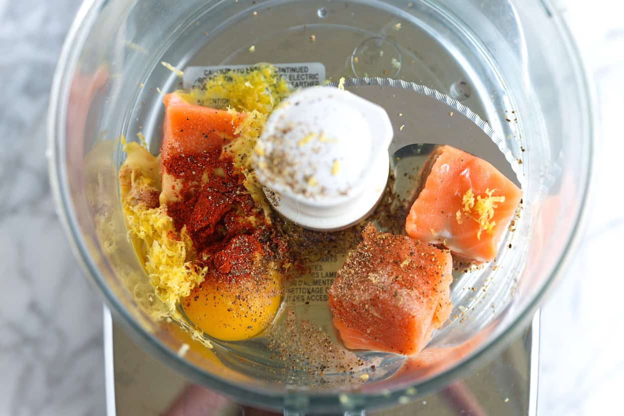 Fresh salmon, egg, mustard, lemon zest, and seasonings in a food processor to make a binder for salmon burgers