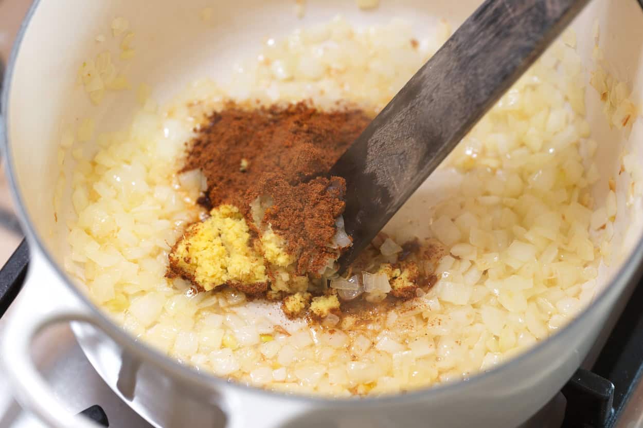 Cooking finely grated ginger, garlic, and spices for tikka masala curry sauce
