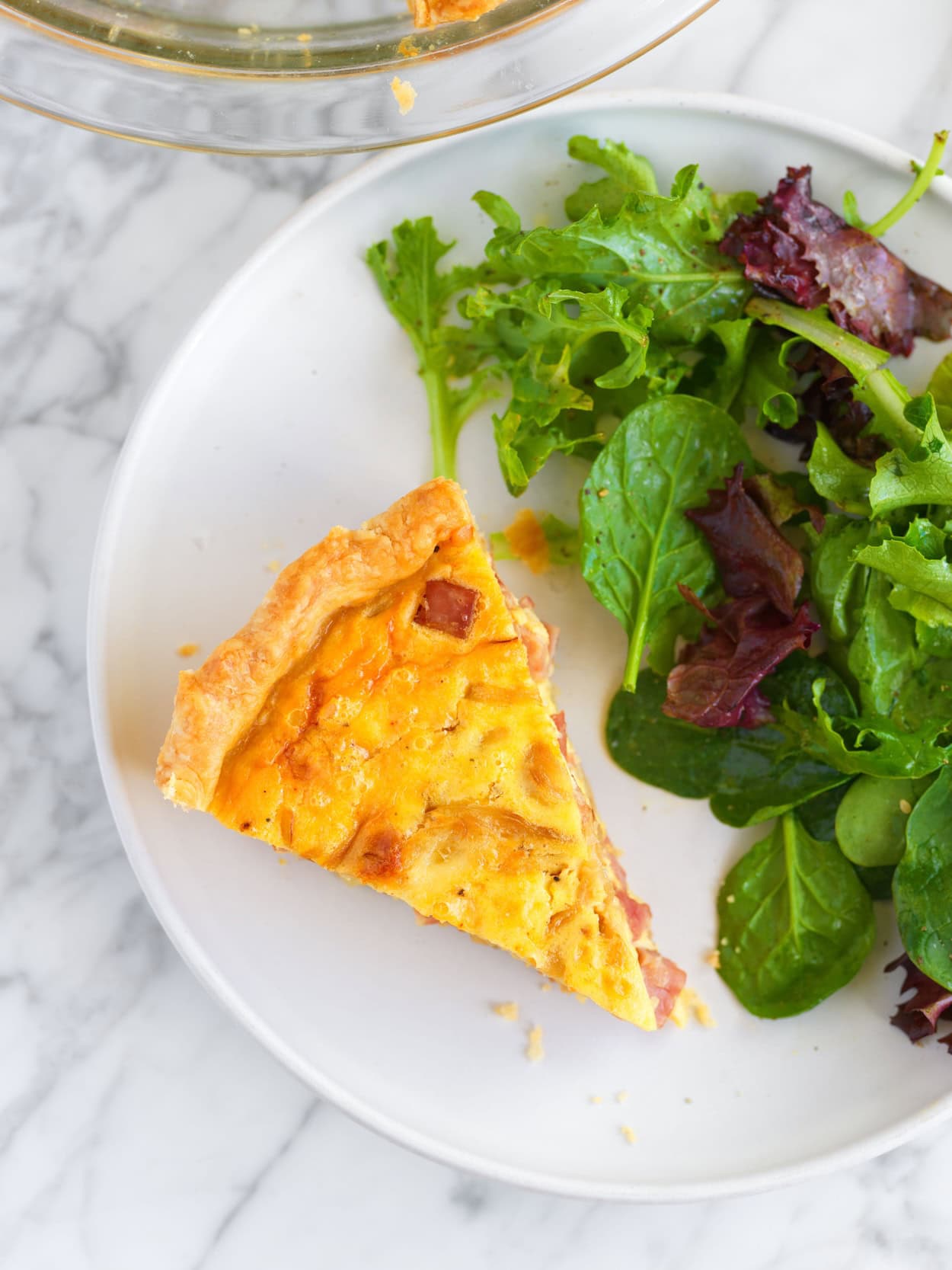 Slice of quiche with salad on the side