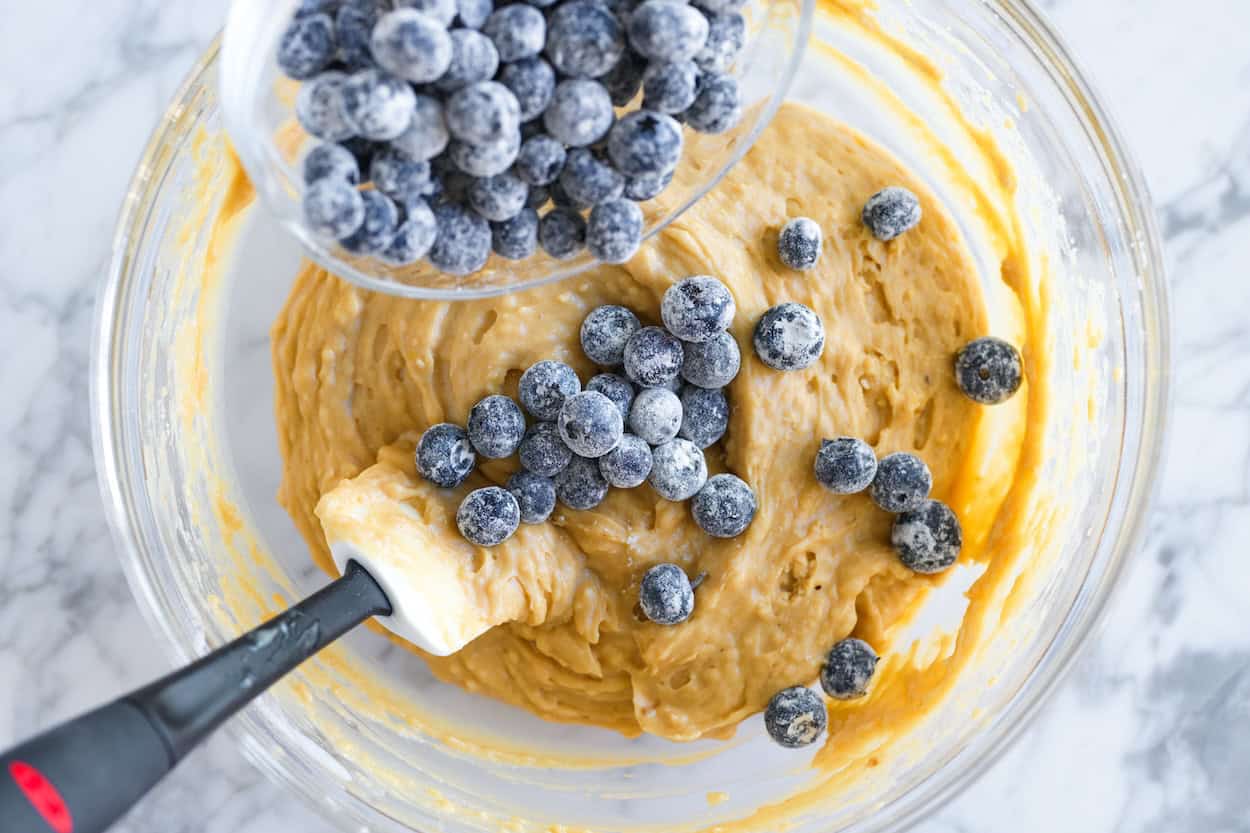 Folding floured blueberries into blueberry bread batter