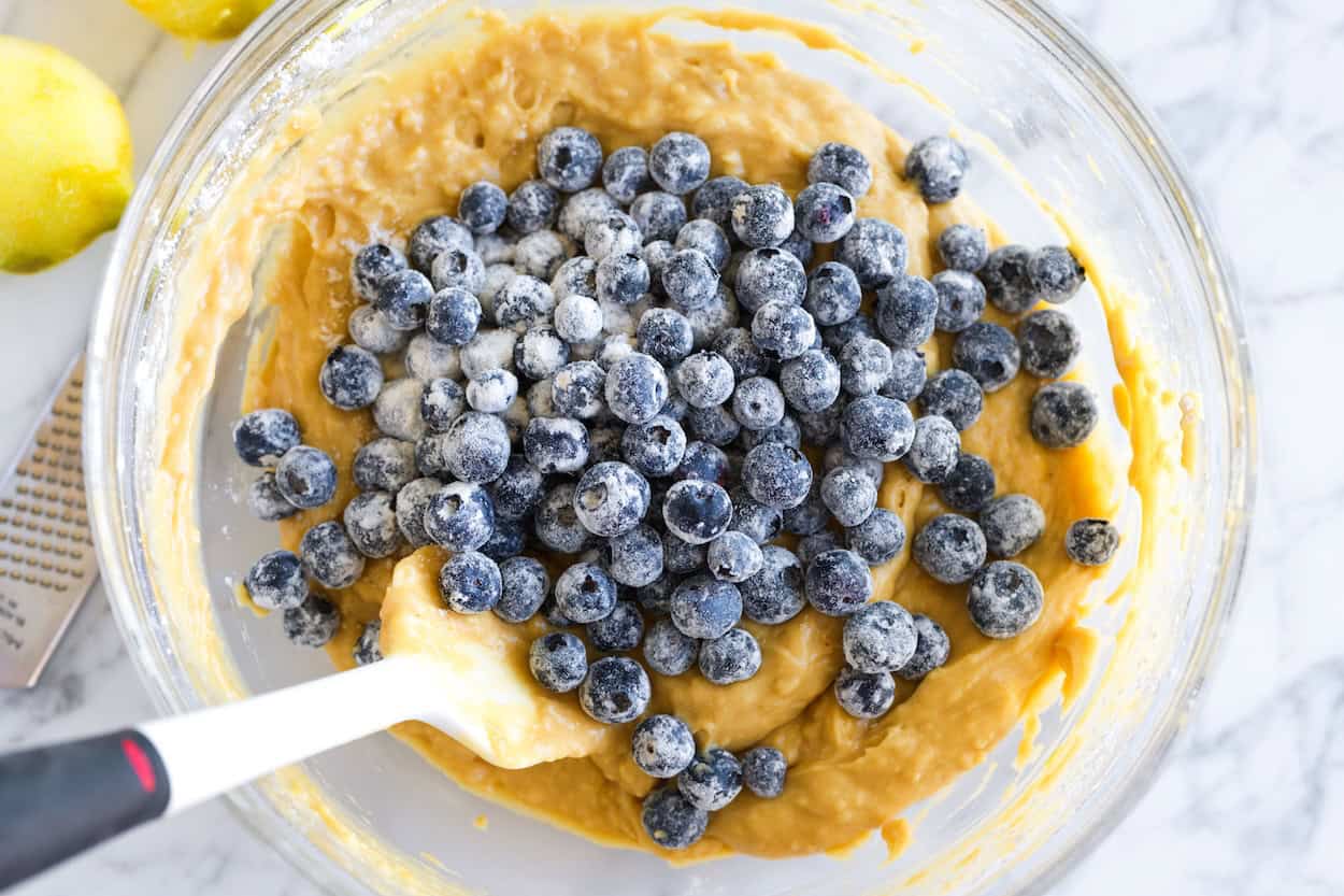 Adding floured blueberries to the bread batter