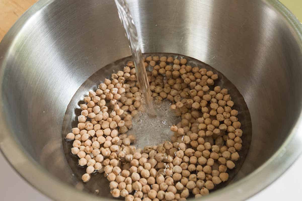 Soaking dried chickpeas in a bowl covered with water for falafel