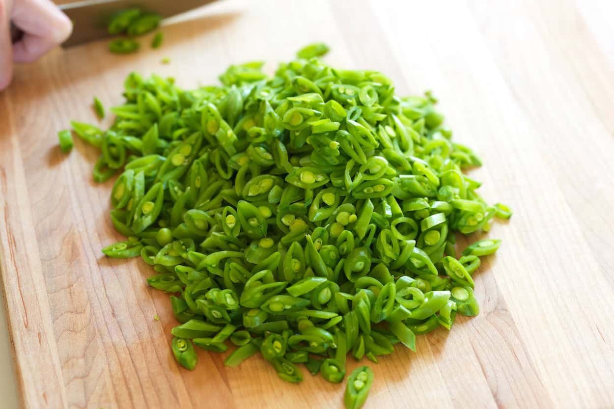 Thinly slicing sugar snap peas for a salad
