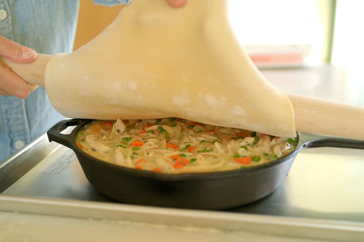 Adding puff pastry to the top of pot pie.